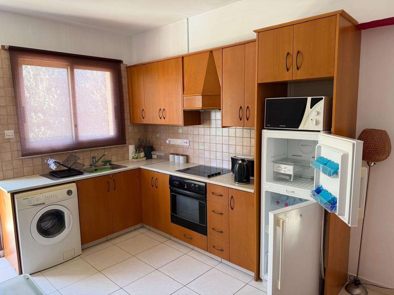 Kitchen before renovation with wooden cabinets and old fittings