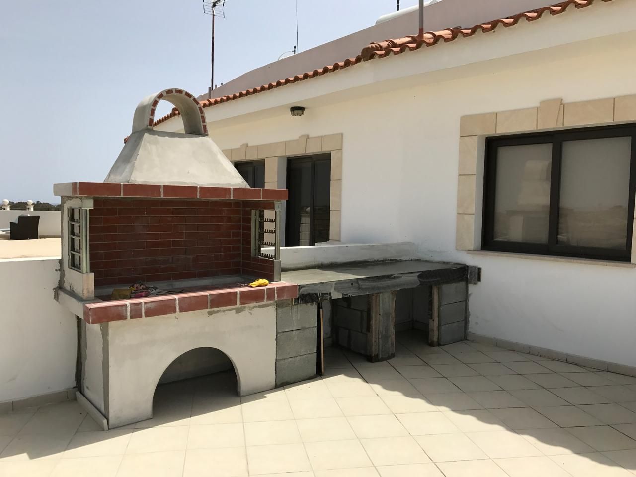 Brick built-in BBQ and outdoor counter base under construction on a penthouse roof terrace