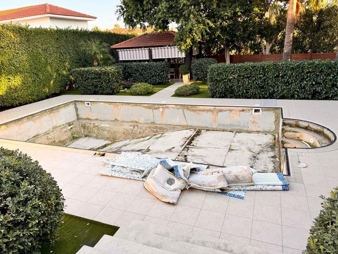 Swimming pool stripped during renovation, with the old liner removed