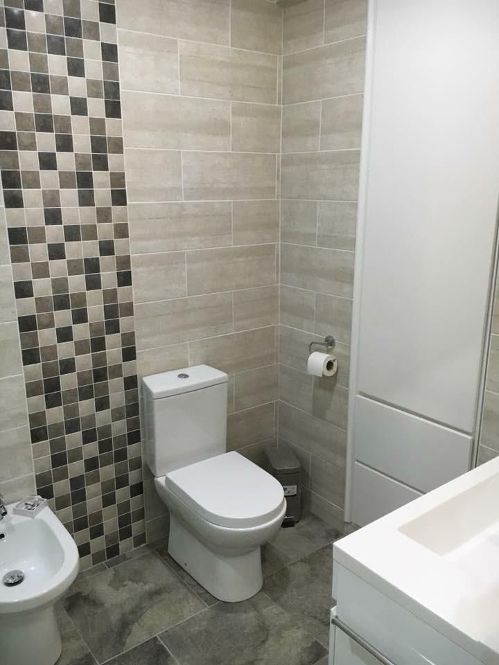 Renovated bathroom with grey tiling, a mosaic feature strip and modern white fittings
