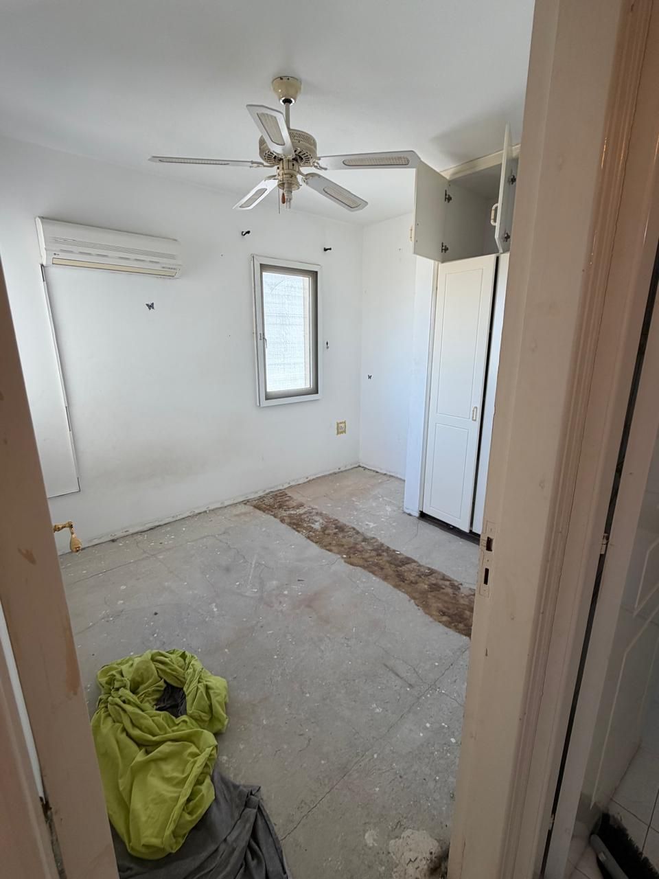 Bedroom during apartment renovation with flooring removed