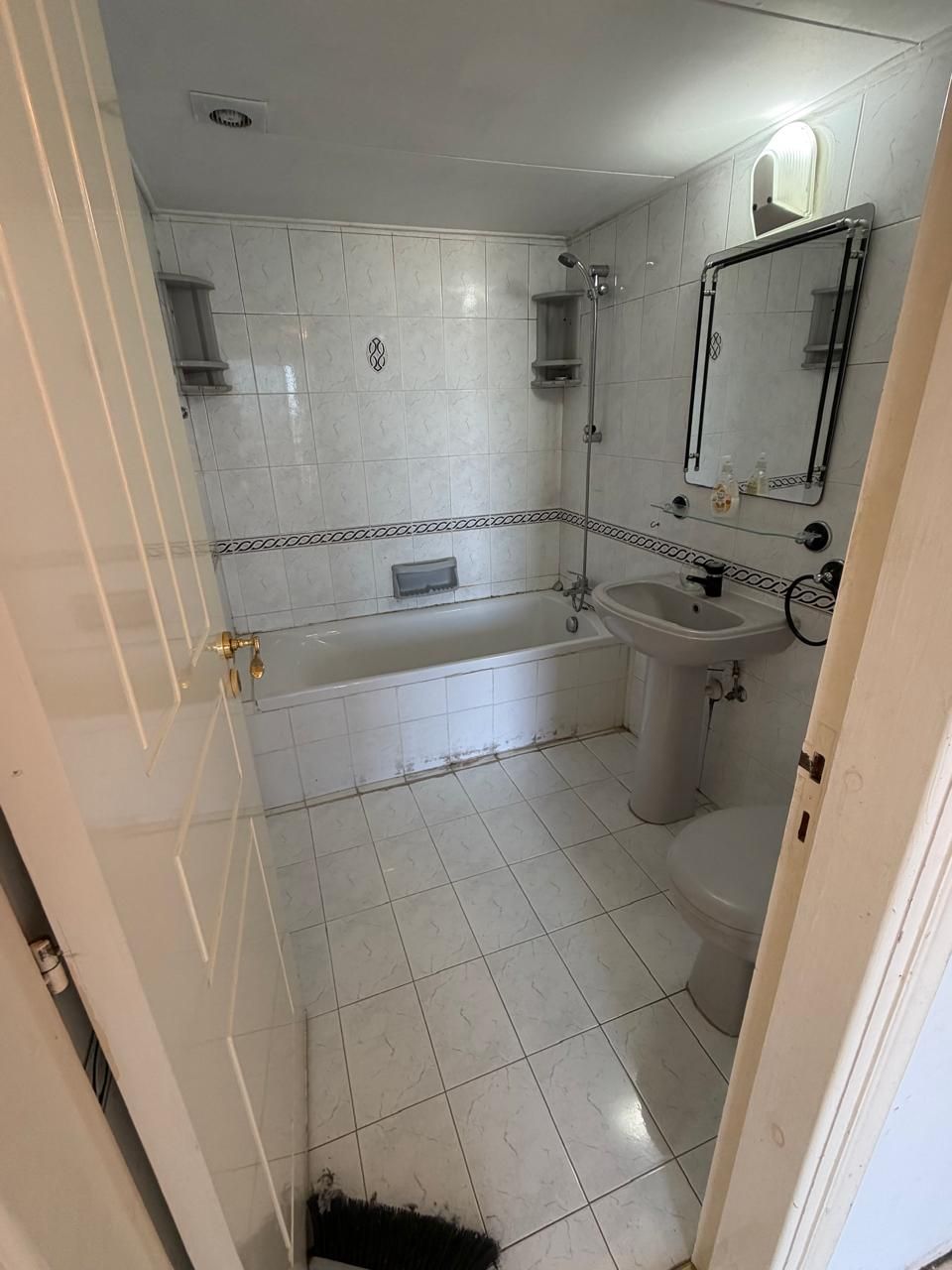 Bathroom before renovation with bath and older fittings