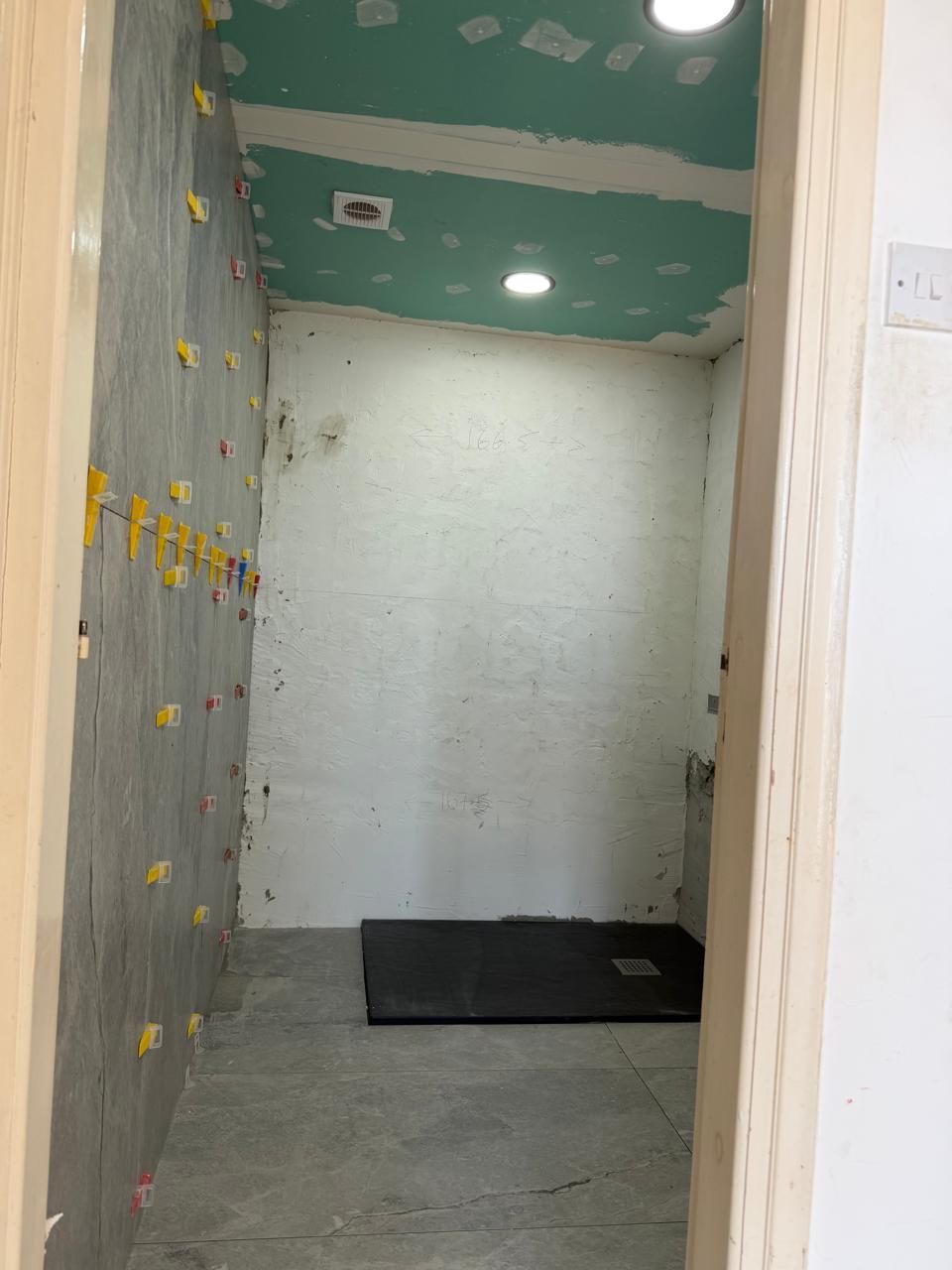 Bathroom renovation in progress with new wall tiling and the shower tray fitted