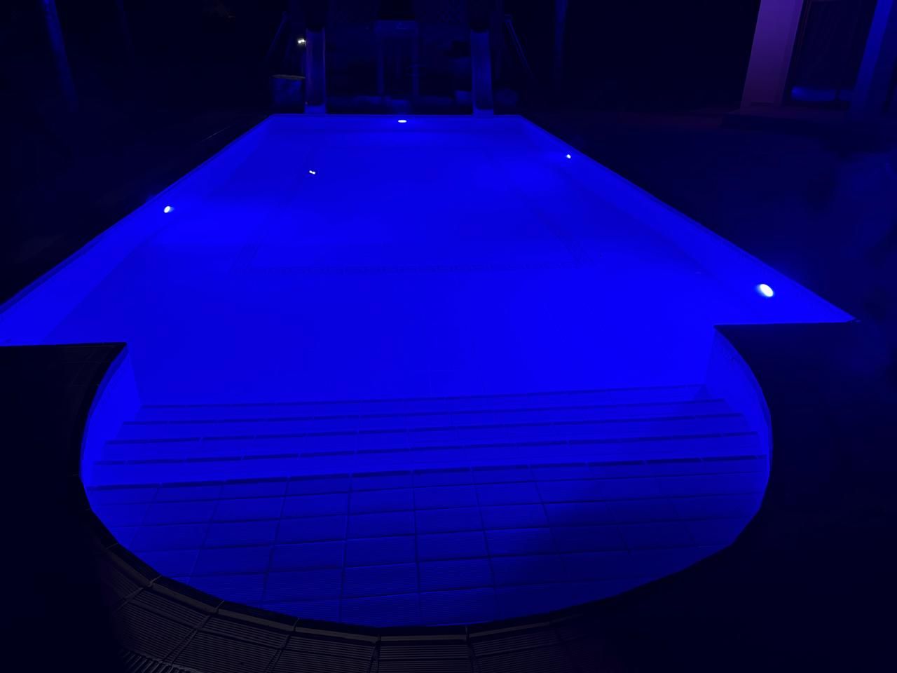 Swimming pool with blue LED lighting at night