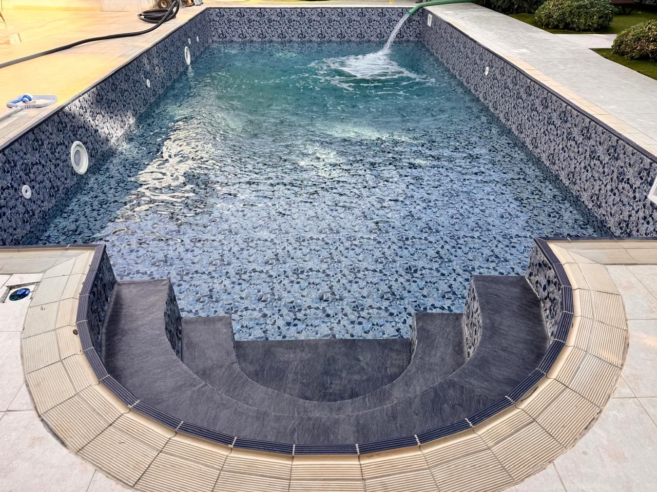 Renovated swimming pool being filled with water